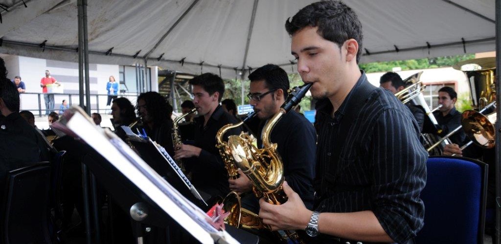 Orquesta sinfónica, en primer plano aparece joven tocando saxofón