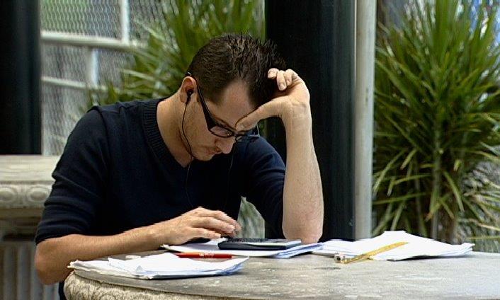 Joven concentrado estudiando en una mesa al aire libre